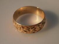 An 18ct gold engraved wedding band