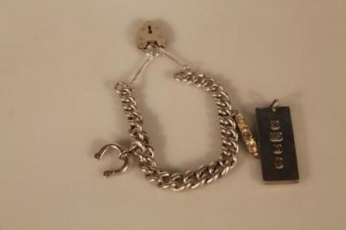 A heavy silver curb link bracelet and an ingot pendant