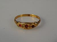 An 18ct gold dress ring with three red stones