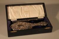 A cased silver backed hand mirror and matching comb