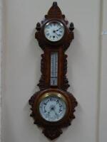 A late 19thC carved oak wall barometer with clock.