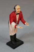 A modern resin figure of a waiter holding a tray