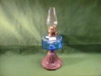 A cast based oil lamp with blue glass reservoir