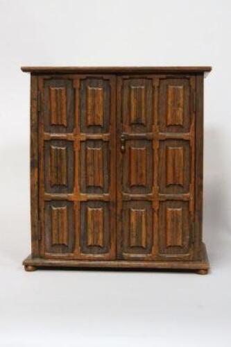 A smokers cabinet carved in the form of a linenfold double wardrobe