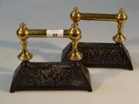 A pair of brass and cast iron poker rests.