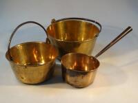 A set of two graduated brass jam pans and a saucepan