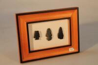 Three framed flint arrowheads.