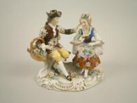 A Dresden porcelain group in the form of a gentleman and lady with flowers