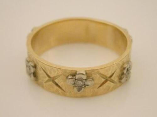 An 18ct gold band with floral motifs