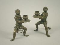 A pair of cast bronze monkey candlesticks