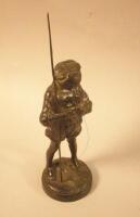 A cast iron figure of a young boy and his fishing rod