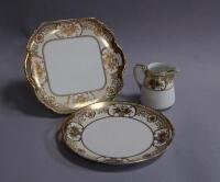 A Noritake cream and gilt part tea service and a pair of cut crystal decanters.