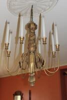 A gilt pendant light fitting with with ribbon and tasselled stem an three matching wall lights