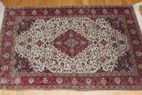 A small Eastern bordered rug with lozenge centre on a red and beige ground