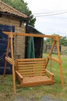 A wooden framed swinging garden seat