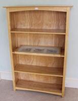 An open bookcase of four shelves and a picture