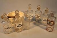 Various apothecary bottles and a pestle and mortar.