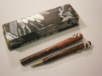 A pair of red mottled fountain pens and pencils