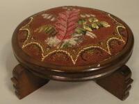 A mahogany stool inset with a Victorian beadwork panel of leaves