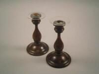 A pair of 19thC turned fruit wood and brass mounted candlestick