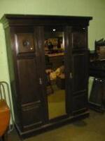 An Edwardian dark stained ash triple wardrobe with centre mirror door