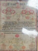 A framed sampler depicting floral images and religious verse