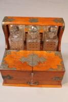 An Edwardian oak cased three bottled tantalus