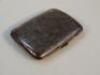 A George V silver pocket cigarette case engraved with scroll decoration