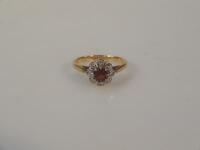 An orange stone and tiny diamond cluster dress ring