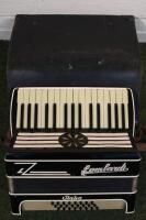 A Lombard Italia piano accordion in case.