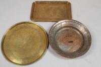 A copper circular dish and two Middle Eastern trays.