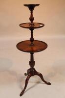 A mahogany three-tier circular dumb waiter