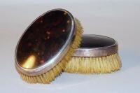 A pair of silver and tortoiseshell hair brushes.