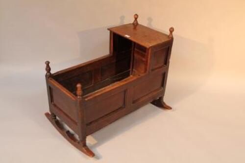 A late 18thC/early 19thC oak cradle with turned finials