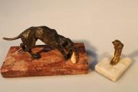 A small cast bronze figure of a dog with a bone