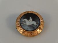 A carved agate cameo brooch depicting a horse and jockey