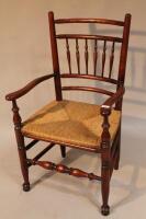 A 20thC spindle back rush seated armchair.