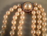 A triple string cultured pearl necklace