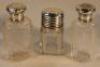 Three Edwardian silver capped scent bottles