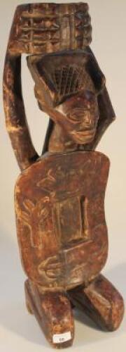 Tribal Art. A carved hardwood figure of a kneeling male