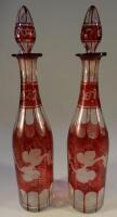 A pair of late 19thC ruby wash decanters decorated with grapes