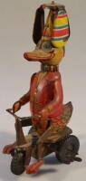 A tinplate clockwork toy of a duck riding a tricycle