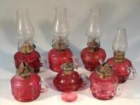 Various 19thC cranberry glass reservoir hand held oil lamps.