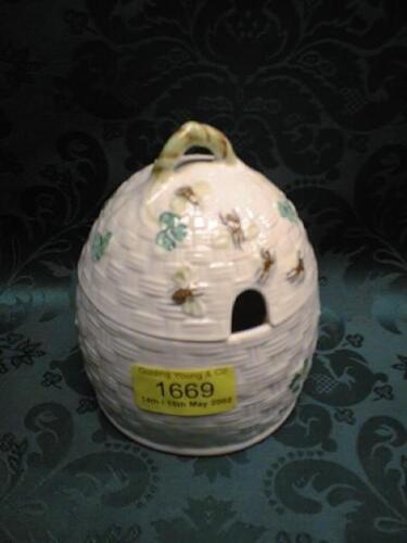 A Belleek honey pot, modelled as a beehive, painted with shamrocks and