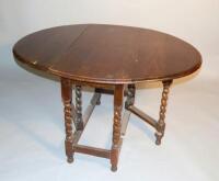 An early 20thC oak oval dropleaf table