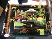 A lacquered oriental photo album and two photo frames.