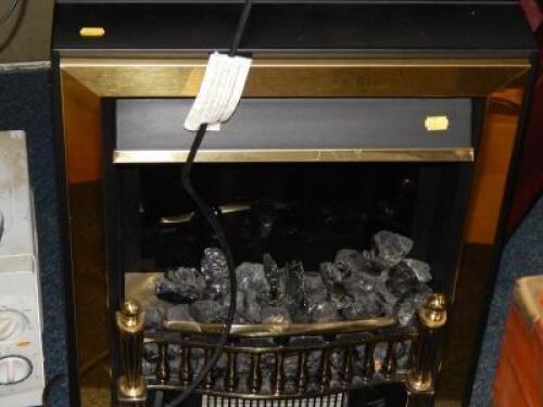 A coal effect electric fire with brass surround.