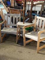 A pair of slatted garden chairs with table attached and a parasol and base.