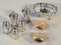 A pair of silver pepperettes with silver Edwardian salts