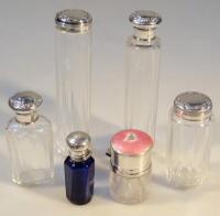 A collection of silver capped scent bottles and dressing table jars